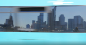 Spiegelung der Frankfurter Skyline in den Fenstern eines fahrenden Nahverkehrsmittels.